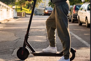 Group of friends riding e-scooters along a scenic coastal path.